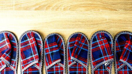 A lot of colorful comfortable, cushioned, checkered disposable slippers are on the wooden floor. Top view. Concept of hospitality. Close-up. Indoors.の写真素材