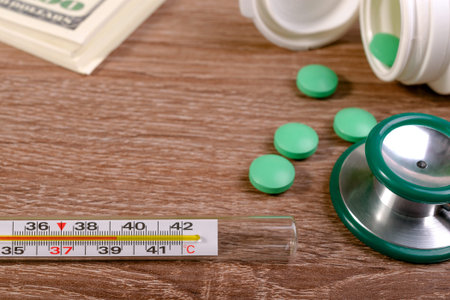 High fever is first sign of coronavirus infection or Covid-19. Stethoscope, pills, thermometer with...