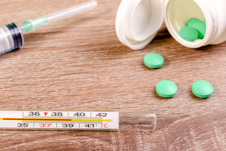 High temperature is first sign of corona virus infection. Spirit or mercury thermometer with high...