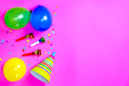 Carnival hats and accessories for birthday celebration lie on bright pink background. Scattered confetti. Copy space for text. Top view. Flat lay. Lay out. Close-up. Holidayの写真素材