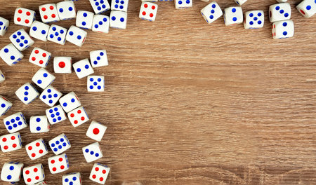 Many white dice with red and blue dots on wooden table. Casino gambling concept. Copy space for...