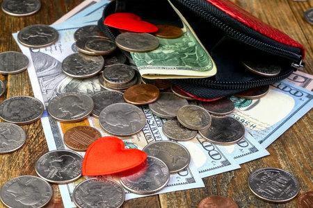 Open wallet with us coins, american dollars banknotes and red heart. Love for money and desire for...