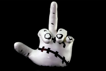 White sculpture in shape of hand showing obscene gesture against black background. Object of modern abstract art. close-up.の写真素材