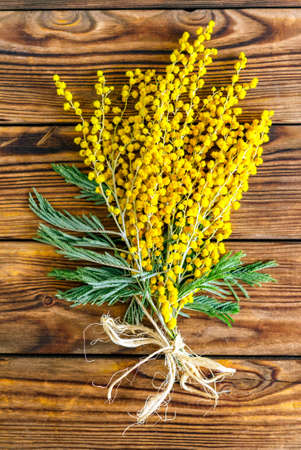 Spring mimosa flower bouquet on an old wooden background. Spring, 8th of march, easter greetings cardの写真素材