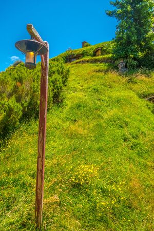 Old roadside lamp in front of lush grass at Hobbiton Movie Set, New Zealandのeditorial素材