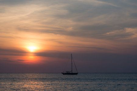 Moody scene of ship on horizon during sunset in Thailand. Royalty free stock photo.