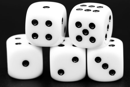 Macro closeup of five dice in front of dark background. Royalty free stock photo.