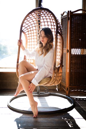 girl sitting in the studio on a swing thoughtfulnessの写真素材