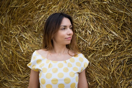 Portrait of a young woman in profile in a haystack in a yellow dress russiaの写真素材