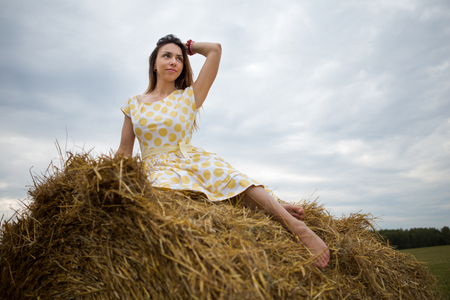 young woman barefoot  in the hay in the field russiaの写真素材