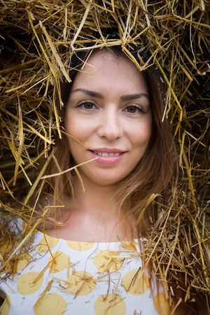Portrait of a young woman in a haystack in a yellow dress russiaの写真素材