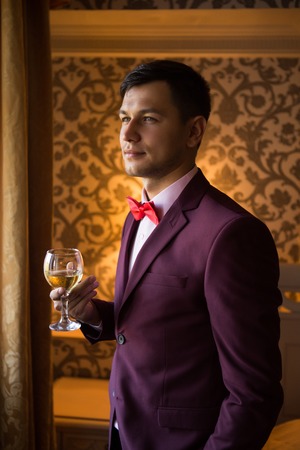 groom drinking wine is going to the wedding looking awayの写真素材