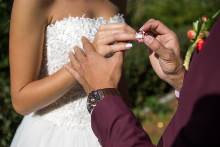 groom wears the ring bride. wedding ceremony outdoorsの写真素材