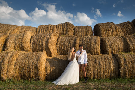 groom bride stand hayloft happy and excited togetherの写真素材