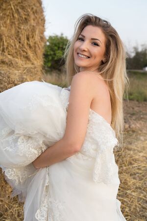 happy bride holds dress laughs looks into cameraの写真素材