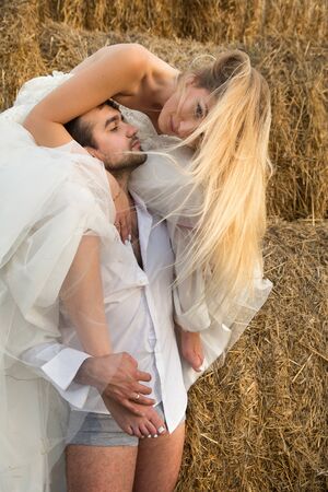 the bride tenderly embraces the groom with their feet and leans towards himの写真素材