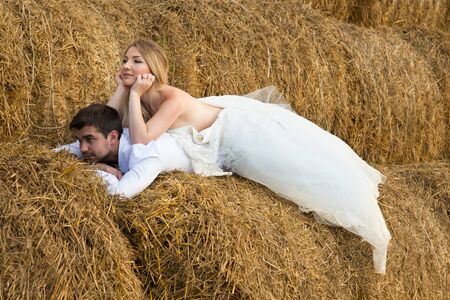the bride tenderly embraces the groom with their feet and leans towards himの写真素材