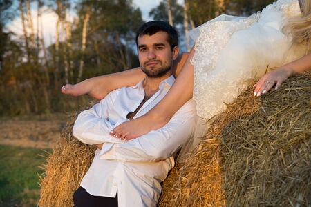 the groom holds the bride on his shoulder and looks forwardの写真素材