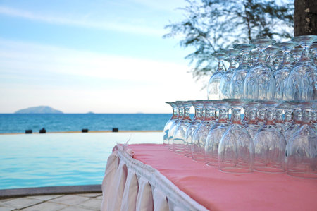 stack of glass on the table near the pool at seaside.