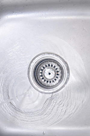The Water Flowing Down In The Hole In A Kitchen Sinkの写真素材