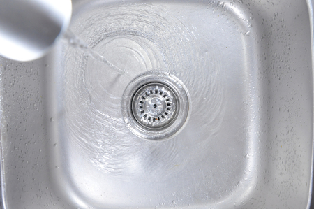 The Water Flowing Down In The Hole In A Kitchen Sinkの写真素材