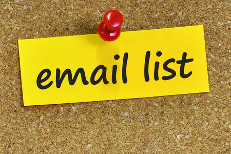 email list word on yellow notepaper with cork background.の写真素材