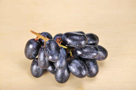 Delicious and fresh black seedless grape on wood plank.の写真素材