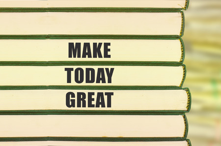 Inspirational motivating quote on stack of books and blur background. make today greatの写真素材
