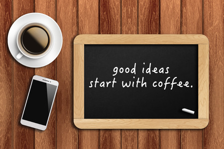 Inspirational motivating quote on chalkboard with coffee, phone and wooden background. good ideas start with coffee.の写真素材