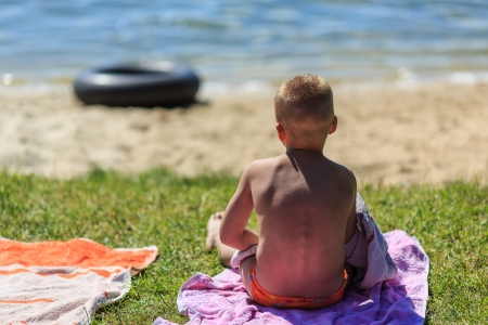 A child sitting on the shore of Lakeの写真素材