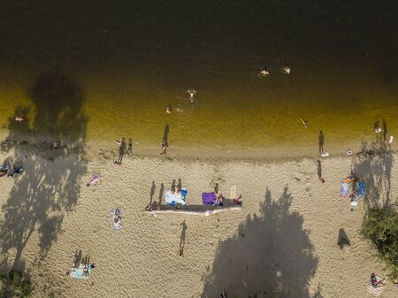People enjoying the beach and swimming in the sea, aerial viewの写真素材