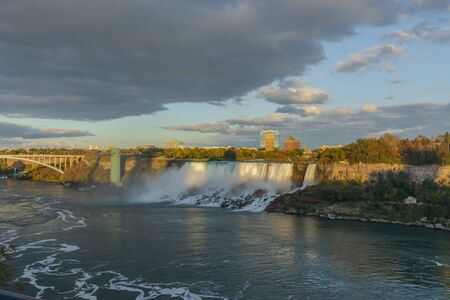Niagara Falls - American Falls and Bridal Veil Falls with a rainbow in the sunset rays of the setting sun. View from Canadian Sideのeditorial素材
