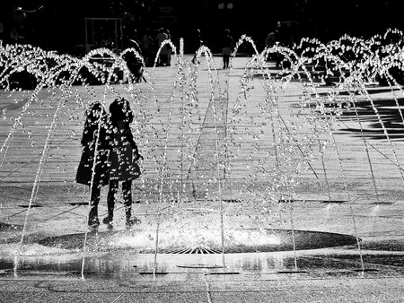 Black and white picture of a fountain with two kids の写真素材