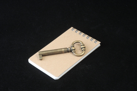 Brown note paper with key on a dark backgroundの写真素材
