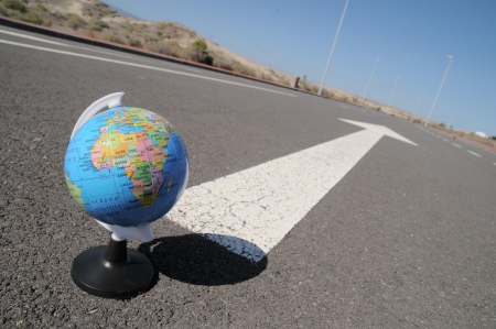 geographic globe and arrow on a asphalt street to the futureの写真素材