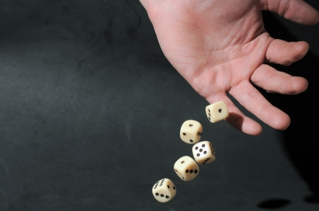 An Hand Play Dice on a Dark Backgroundの写真素材