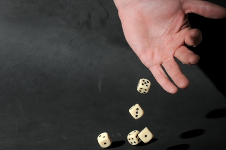An Hand Play Dice on a Dark Backgroundの写真素材