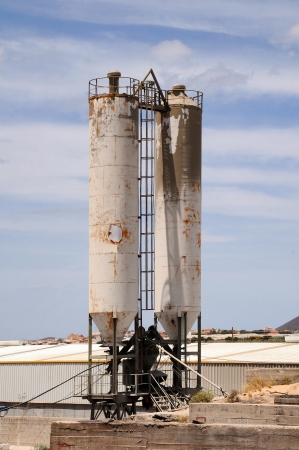 Two Old Ruined White Silos on a Cloudy Skyの写真素材
