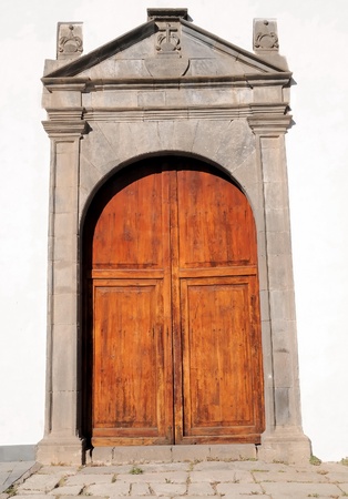 Brown Wooden Door of a Church over a White Wallの写真素材