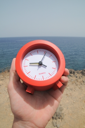 One Red Clock on the Rocks Near the Ocean の写真素材