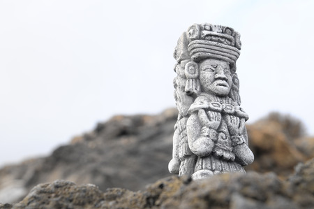 Ancient Maya Statue on the Rocks near the Oceanの写真素材