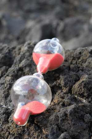 Time Concept - Hourglass Abandoned on the Volcanic Rocks