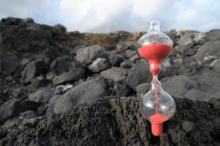 Time Concept - Hourglass Abandoned on the Volcanic Rocksの写真素材