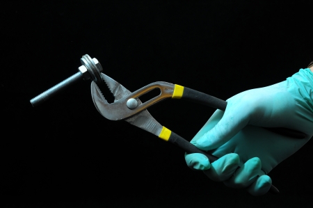 Pliers and a Hand on a Black Backgroundの写真素材