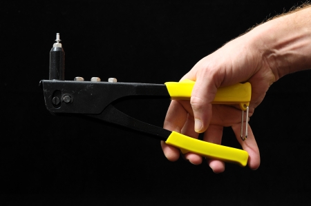 Rivets Pliers and a Hand on a Black Backgroundの写真素材
