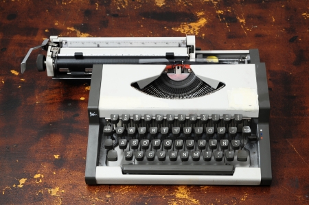Old Vintage Travel Typewriter on a Brown Wooden Tableの写真素材