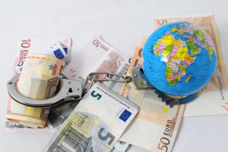 Financial Concept Handcuffs, Earth and Money on a White Backgroundの写真素材
