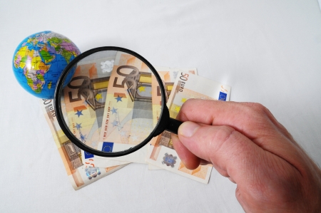 Financial Concept Loupe,Earth and Money on a White Backgroundの写真素材