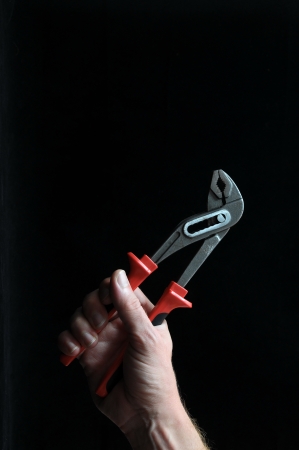 Pliers and a Hand on a Black Backgroundの写真素材