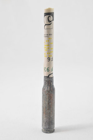 Money and Weapons Concept Bullet and Money on a White 